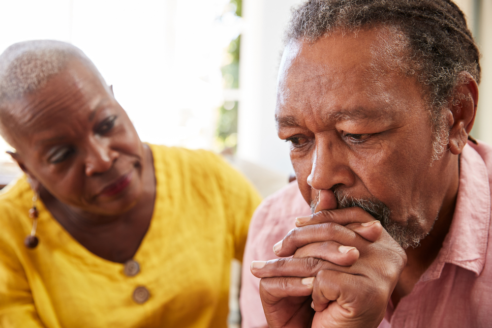 A senior woman comforting a concerned senior man