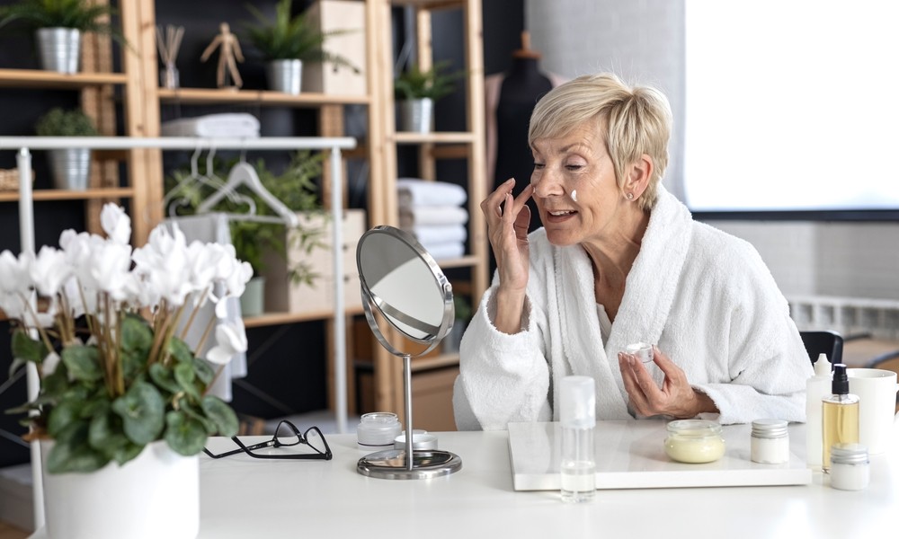 Senior woman applying facial cream