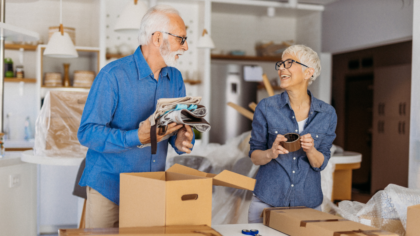 An older woman and older man are packing up the house into boxes