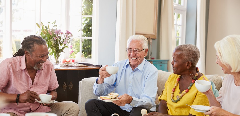 group of four senior friends having a cup of tea