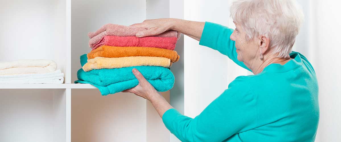 Woman putting towels on a shelf
