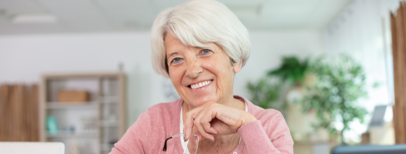 Happy senior woman tracking her expenses