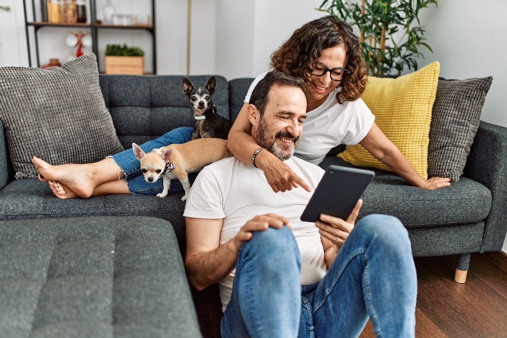 A young senior couple in their early 60s look at a tablet