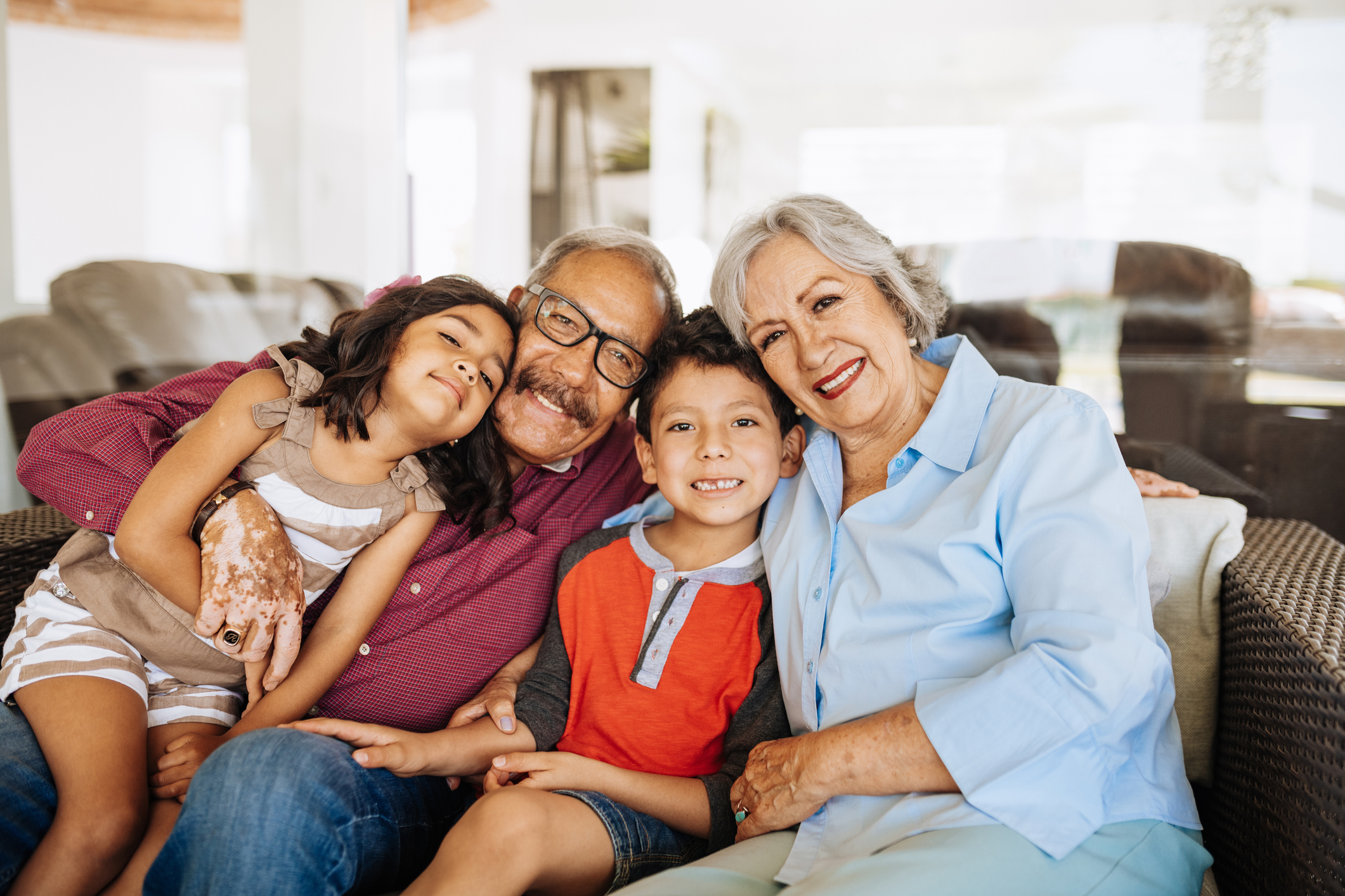 Senior couple sitting on couch with grandkids