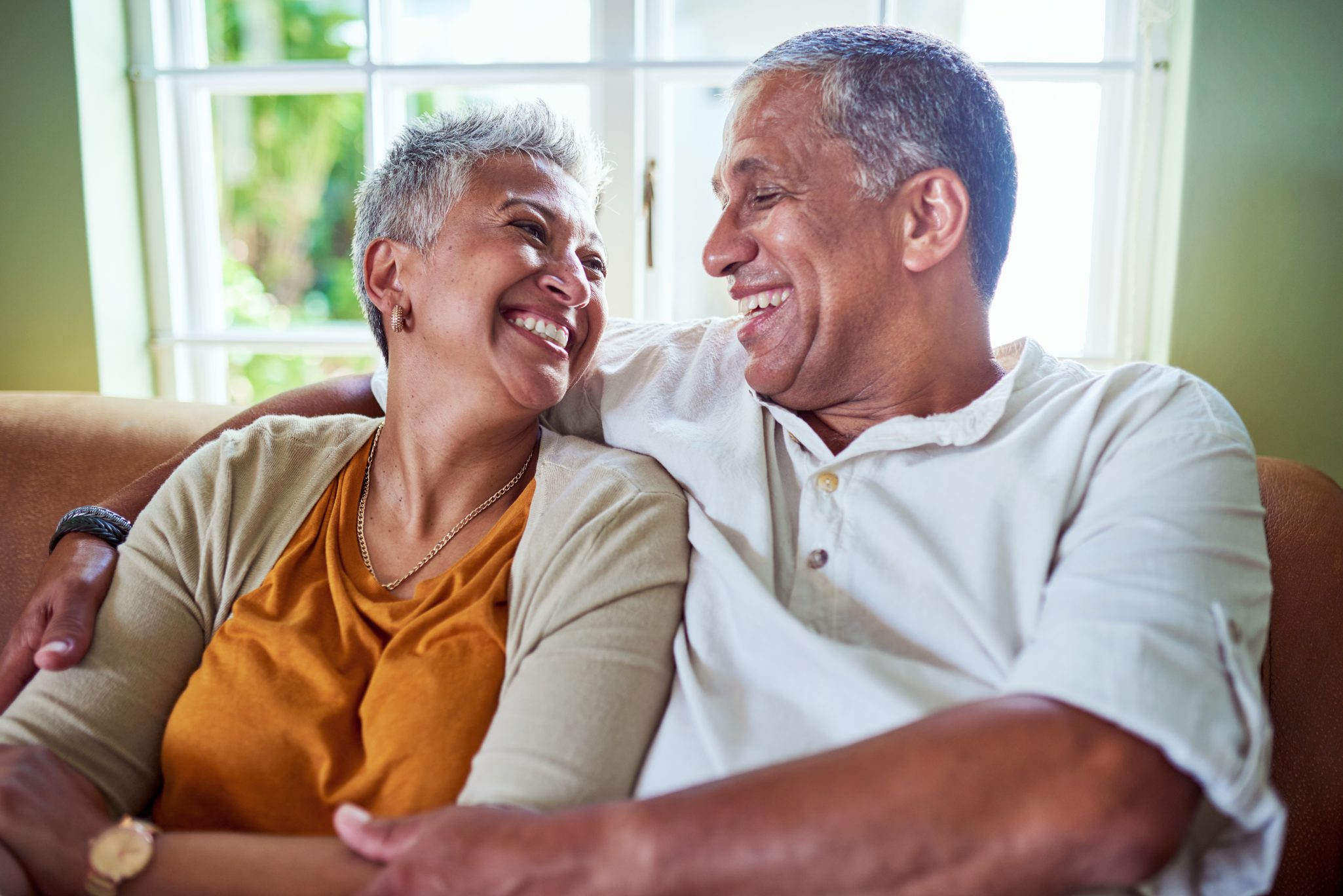 Smiling senior couple sitting on couch together