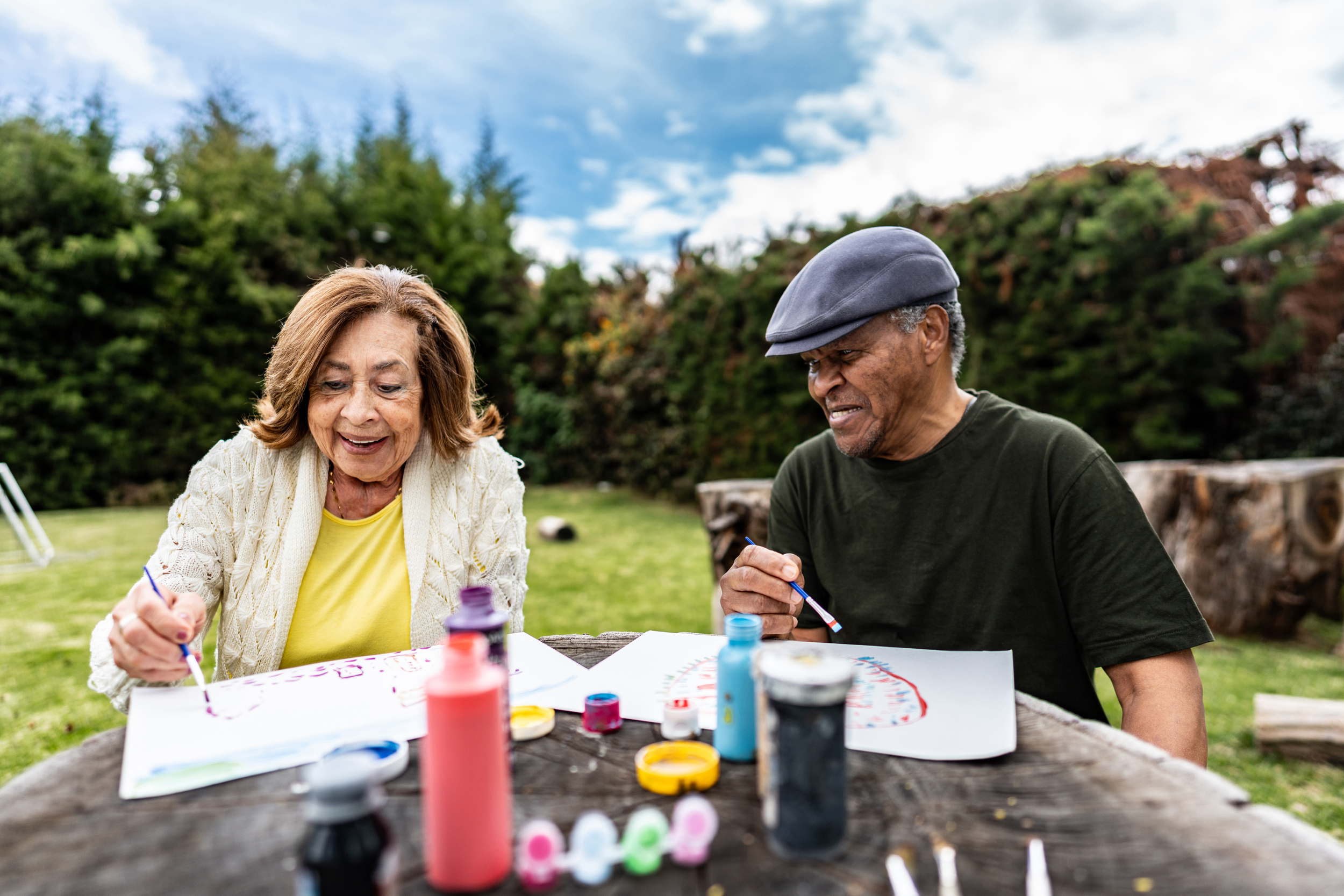 Two seniors painting outdoors