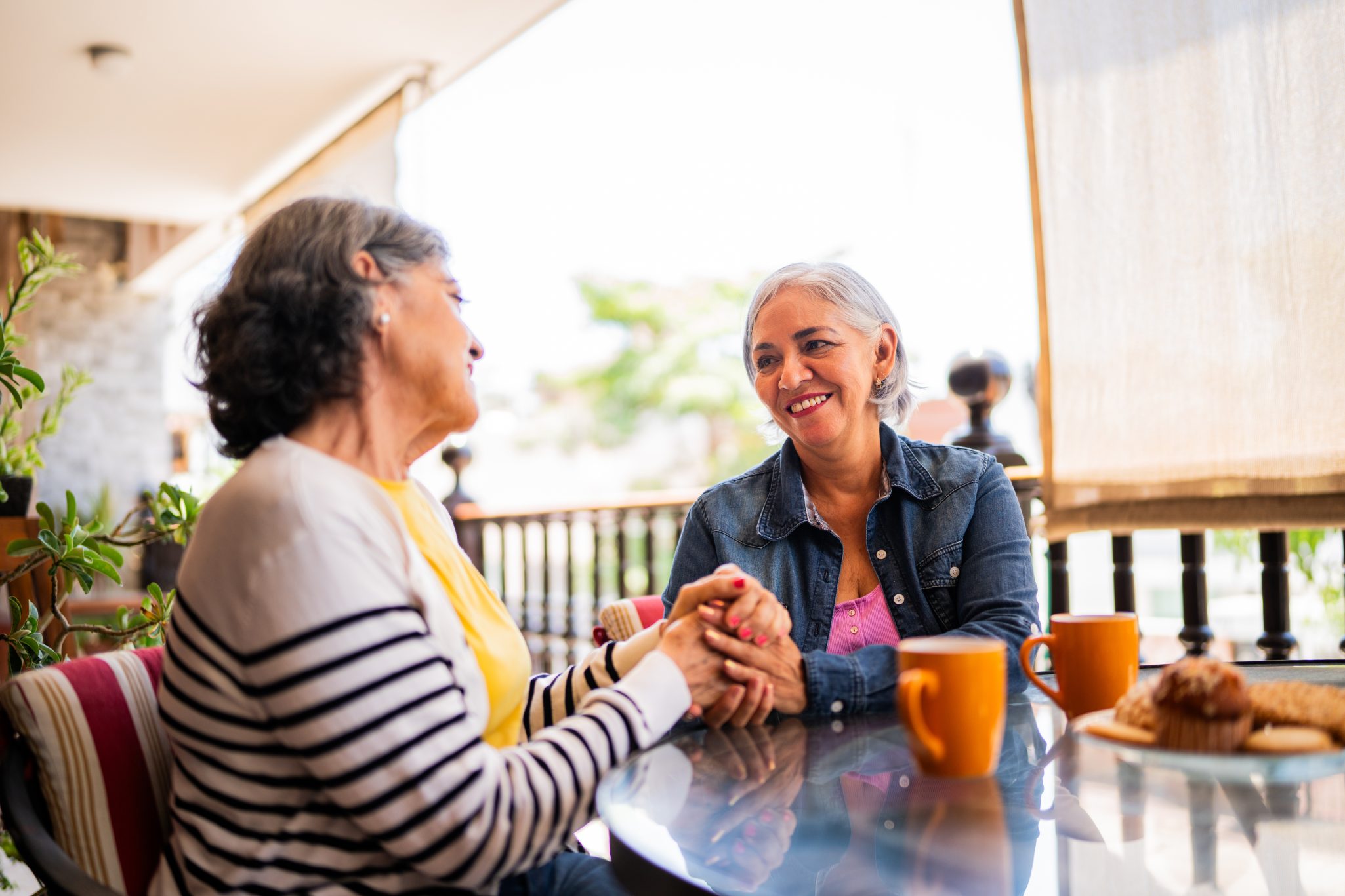 Two senior women friends talking during outdoor breakfast